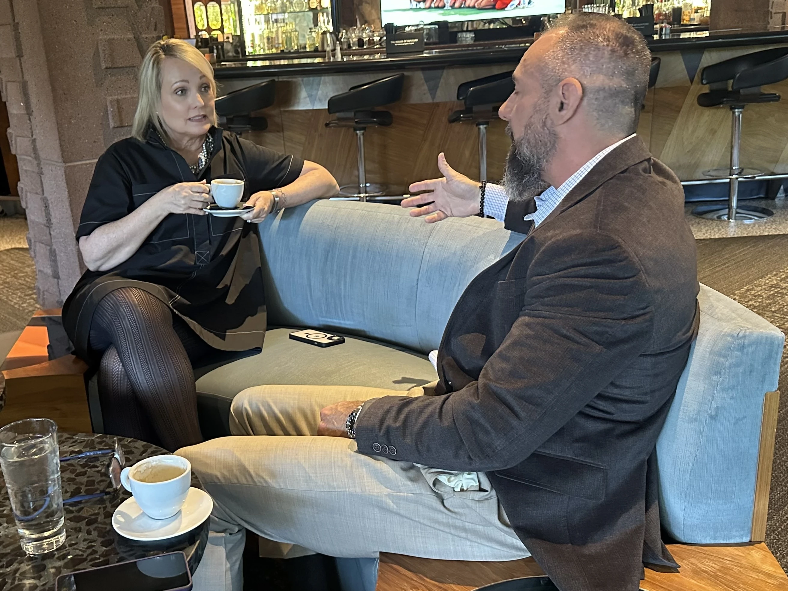 Two Impact Delivered members in candid conversation over coffee